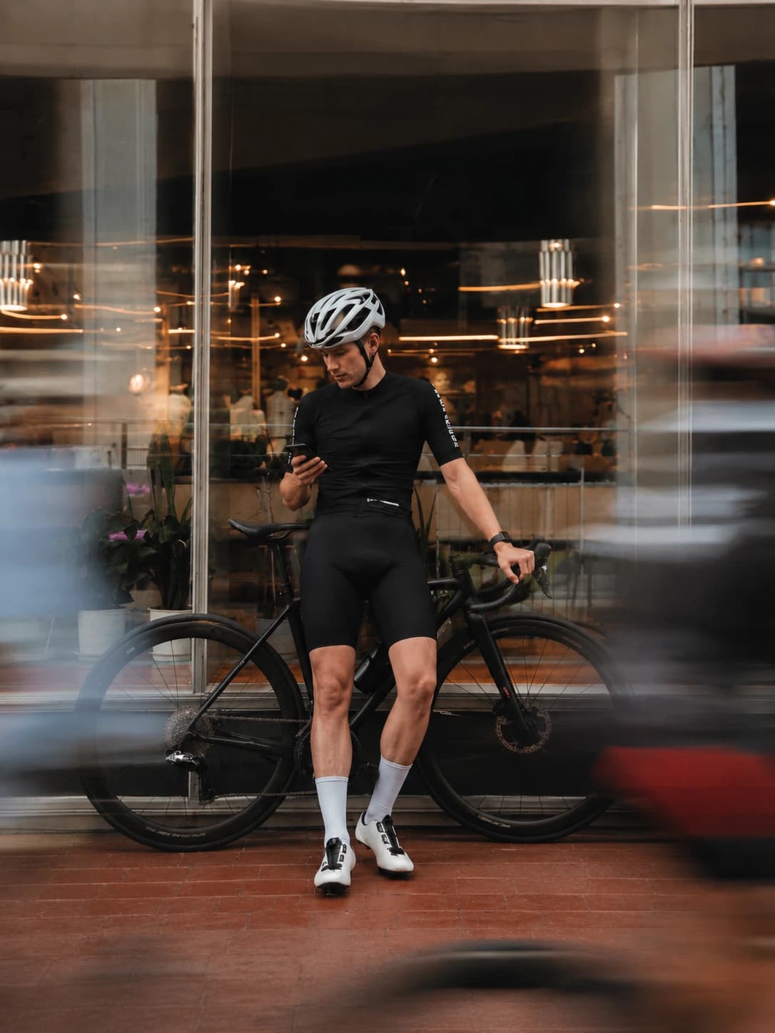 Mit dem Rennrad vor einem beleuchteten Schaufenster